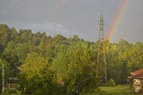 Arc-en-ciel naissant au pied d'un pylône électrique. photo