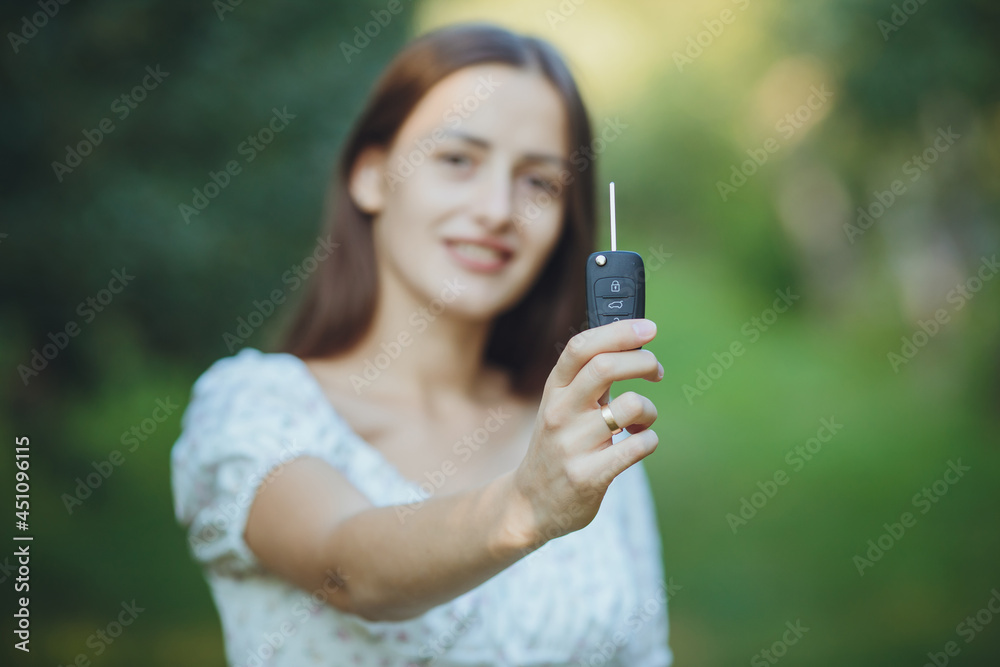 Young beautiful girl holding car keys in hand