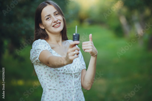 Young beautiful girl holding car keys in hand 