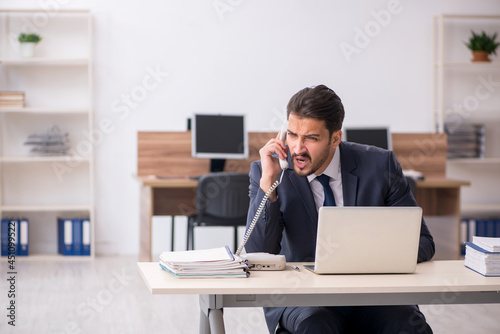 Young male employee sitting at workplace