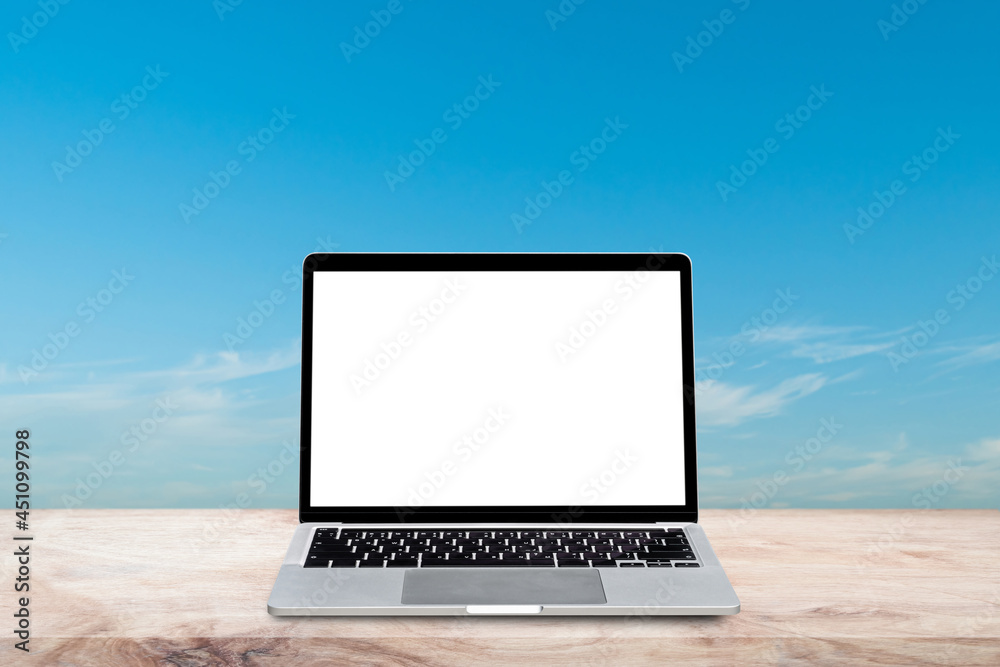 Laptop computer with blank screen on wood table over blur nature sky background. Mock up, template for your design.
