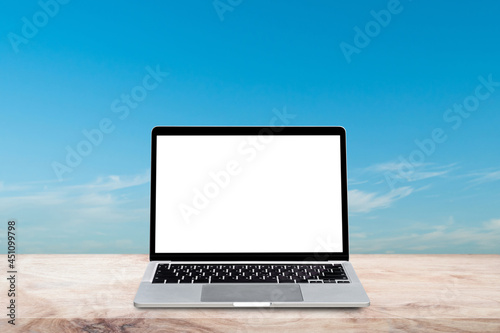 Laptop computer with blank screen on wood table over blur nature sky background. Mock up, template for your design. © banphote