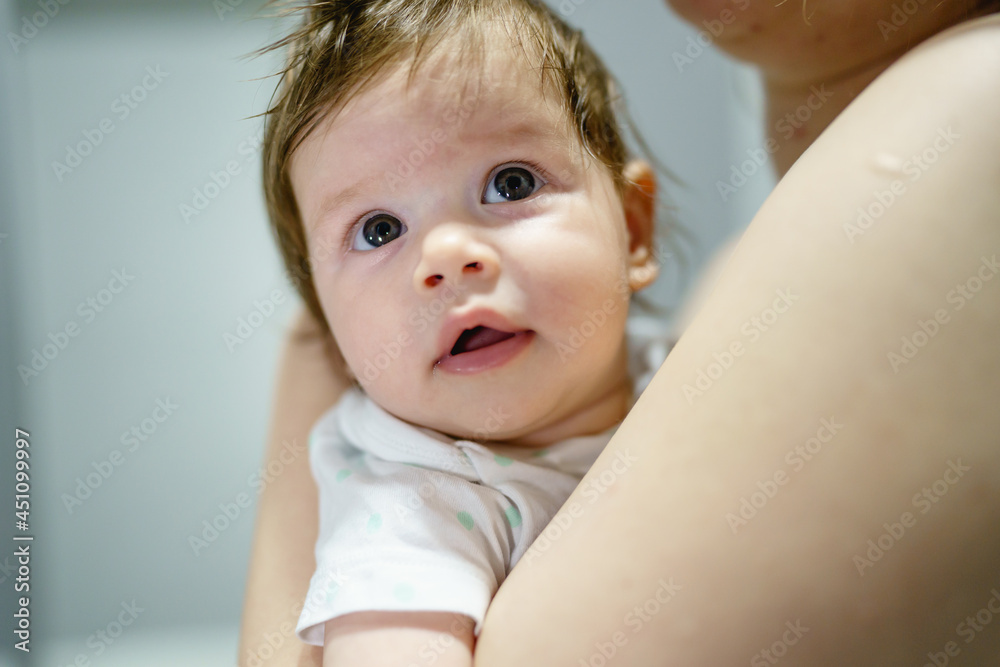 Small caucasian baby in hands of her mother at home woman holding her four months old daughter child close up Small caucasian baby in hands of her mother at home woman holding her four months old daughter child close up