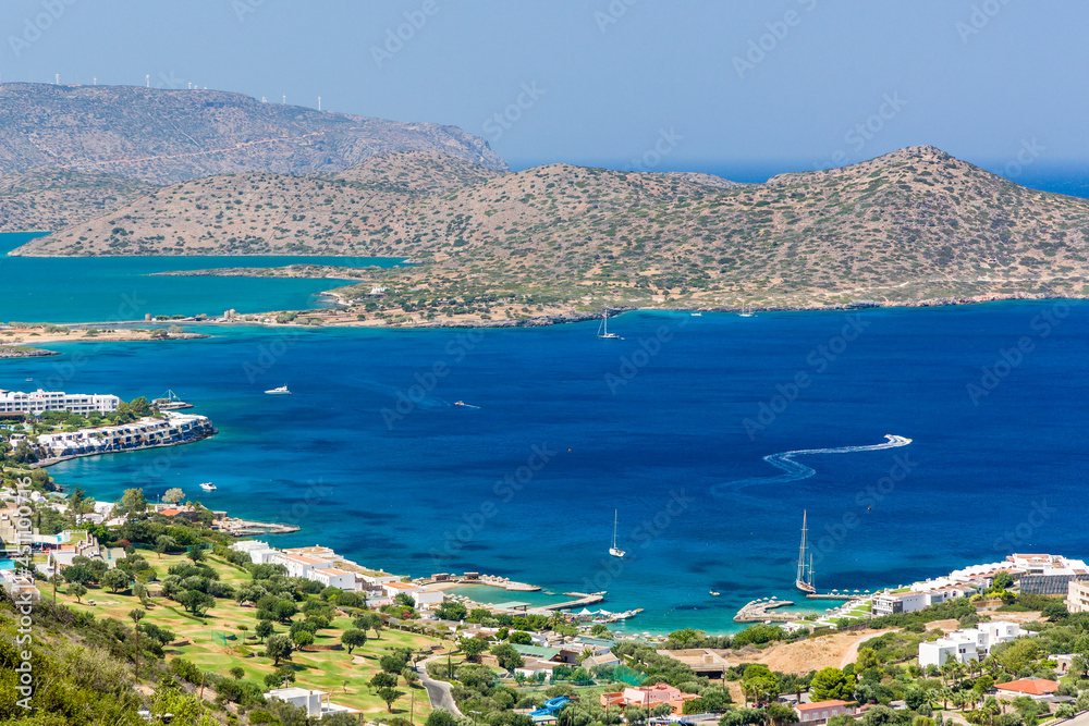 Dry, rocky coastline and clear blue sea of Elounda, Crete, Greece