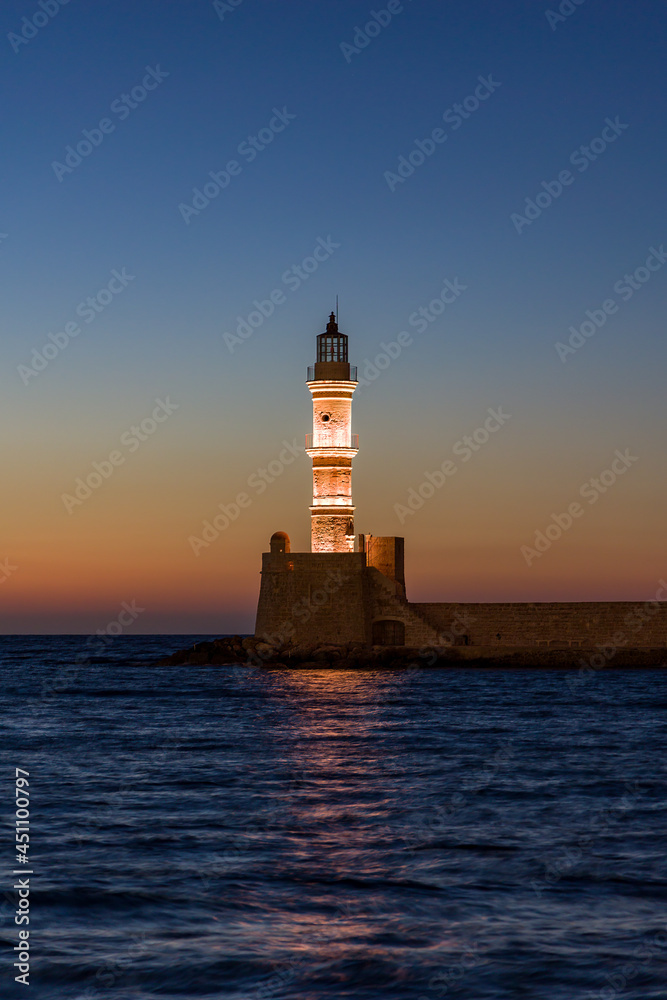 Ancient Venetian lighthouse guarding the old port of Chania, Greece at Sunset