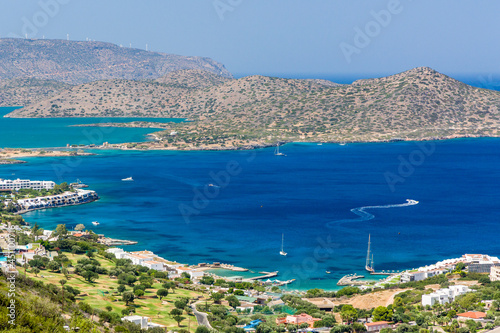 Dry, rocky coastline and clear blue sea of Elounda, Crete, Greece