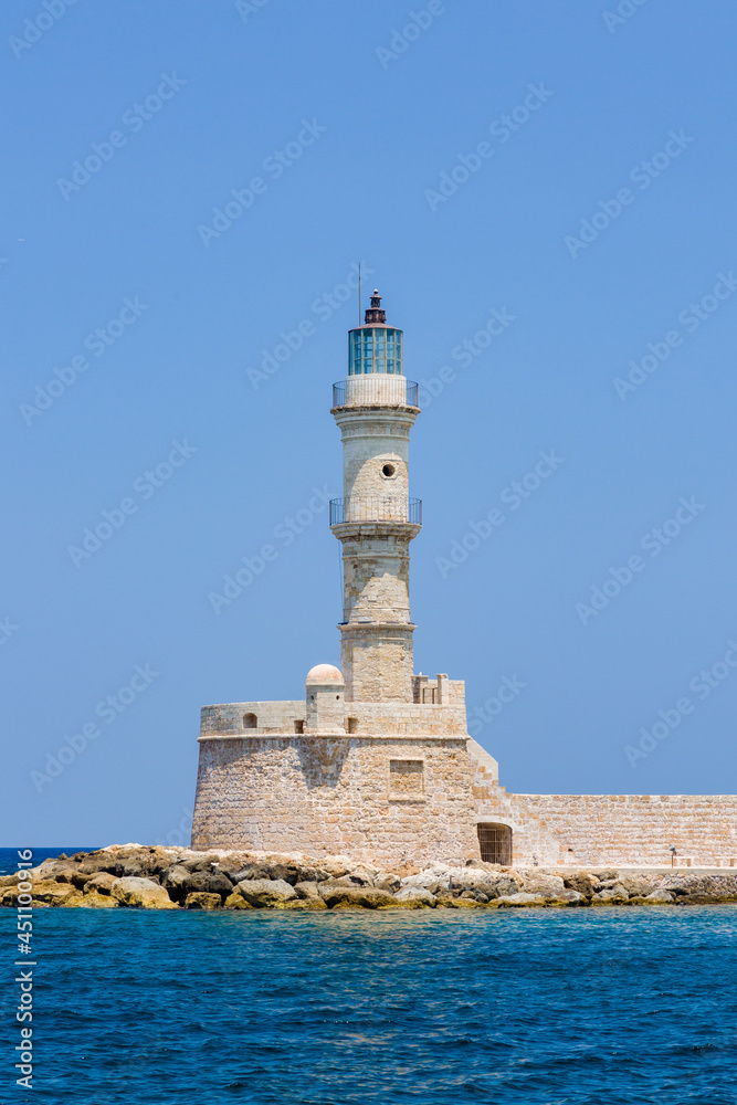 An old stone lighthouse guarding the entrace to a port (Chania, Crete, Greece)