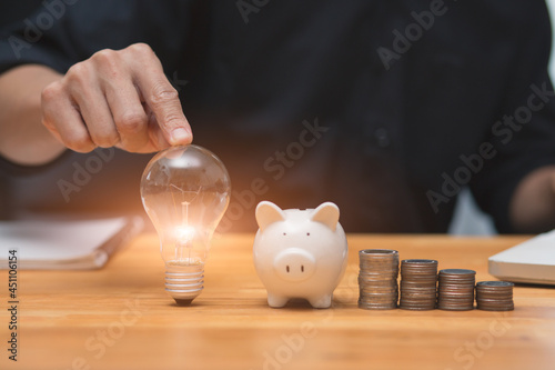 Light bulb Energy saving and pig piggy bank a coin glass on the floor white background