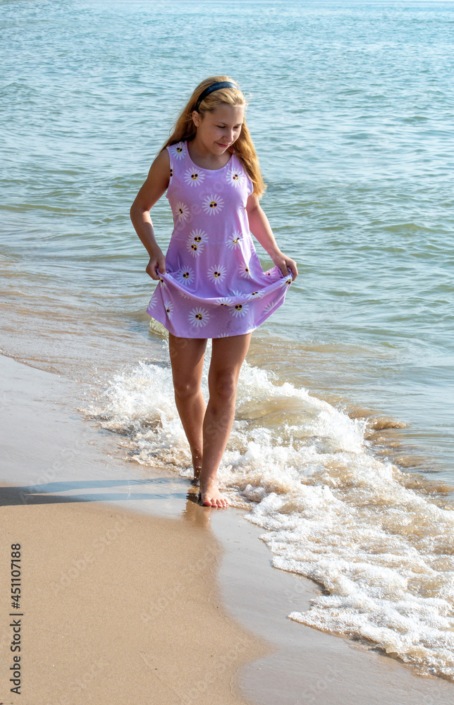 Young girl  walks on a beautiful beach on the shores of Lake Michigan USA