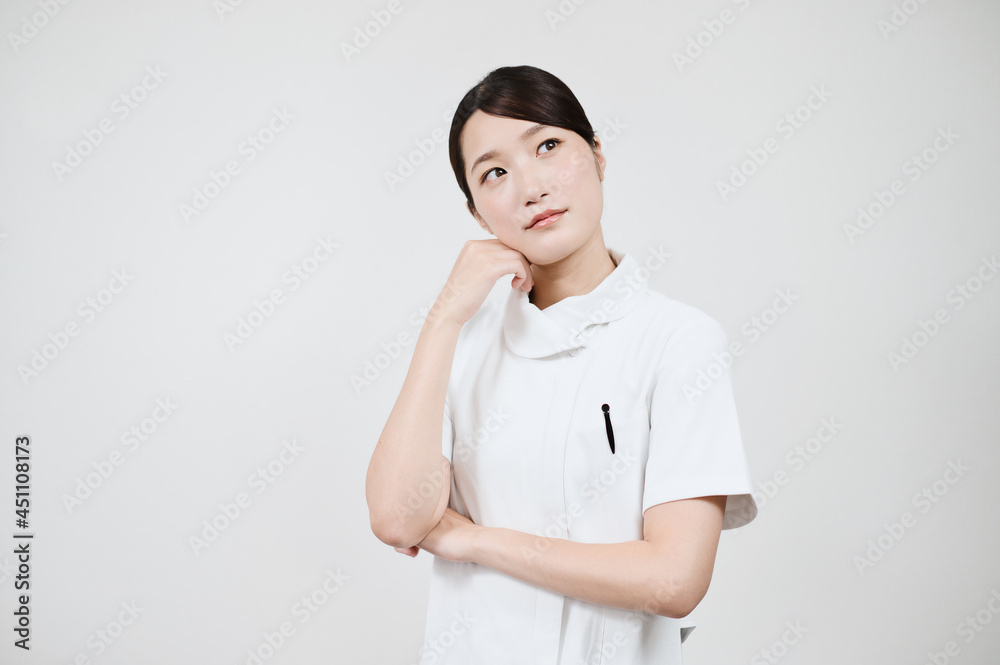 疑問を感じるポーズをする白衣の女性 疑問を感じるポーズをする白衣の女性
