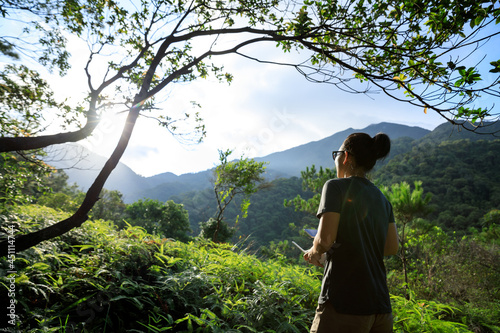 Remotel controlling a  flying drone in tropical forest photo