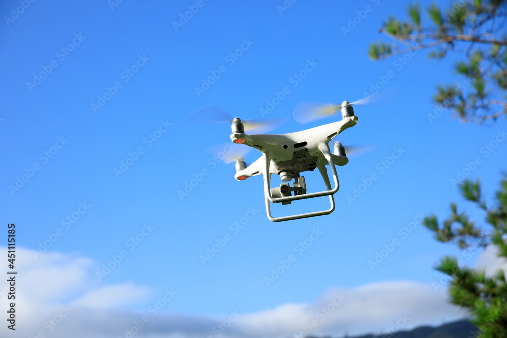 White drone with camera flying in summer mountains White drone with camera flying in summer mountains