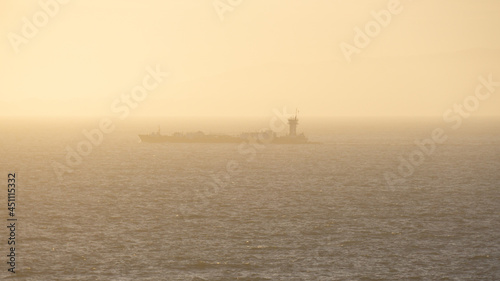 Lone Barge Moving Slowly Along Hazy Shoreline © luca loves cameras