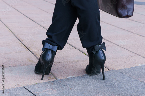 female legs stand, business woman on the street near the office building. Photo without a face