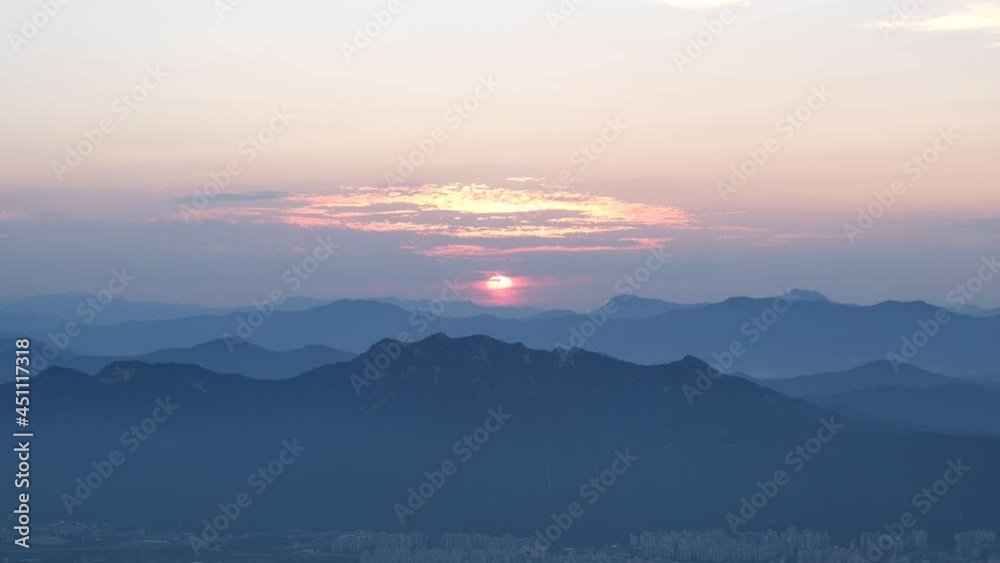 Orange sunset over silhouetted mountain range and valley in South Korea, Asia Orange sunset over silhouetted mountain range and valley in South Korea, Asia