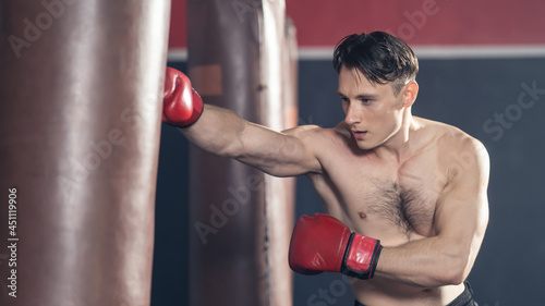 Caucasian sport man in sportswear and boxing glove exercise in fitness © Kawee