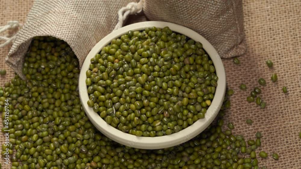 Mung beans on burlap against dark background Mung beans on burlap against dark background