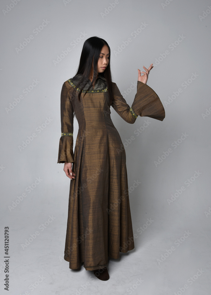 Full length  portrait of beautiful young asian woman with long hair wearing medieval fantasy gown costume. Graceful standing posing  isolated on studio background.