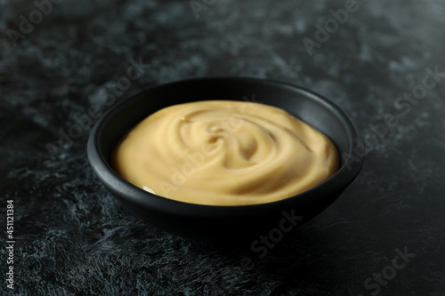 Bowl with cheese sauce on black smokey background