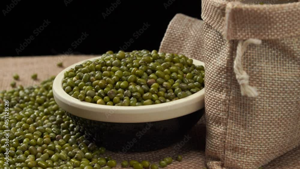 Mung beans on burlap against dark background Mung beans on burlap against dark background