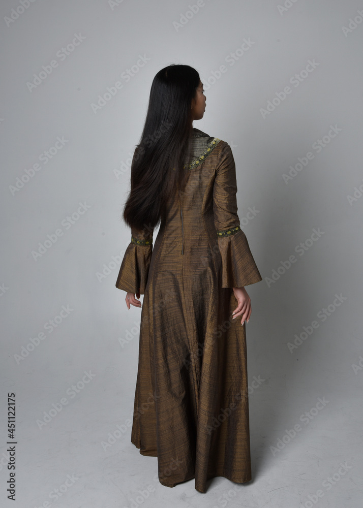 Full length  portrait of beautiful young asian woman with long hair wearing medieval fantasy gown costume. Graceful standing posing walking away,  isolated on studio background.