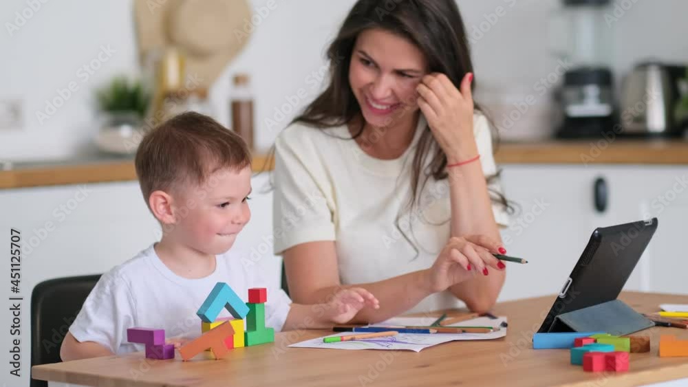 Mother with young boy using digital tablet.happy mom and baby play educational online games on the tablet Mother with young boy using digital tablet.happy mom and baby play educational online games on the tablet
