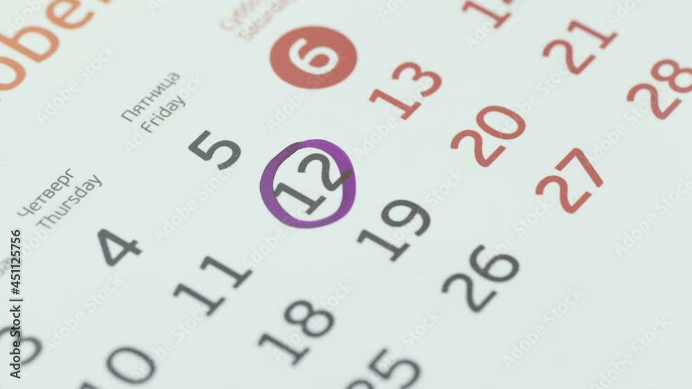 Close-up of the twelfth day of the calendar, signed with a purple pen Close-up of the twelfth day of the calendar, signed with a purple pen