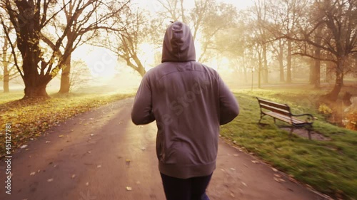Man running in park during sunny autumn morning
