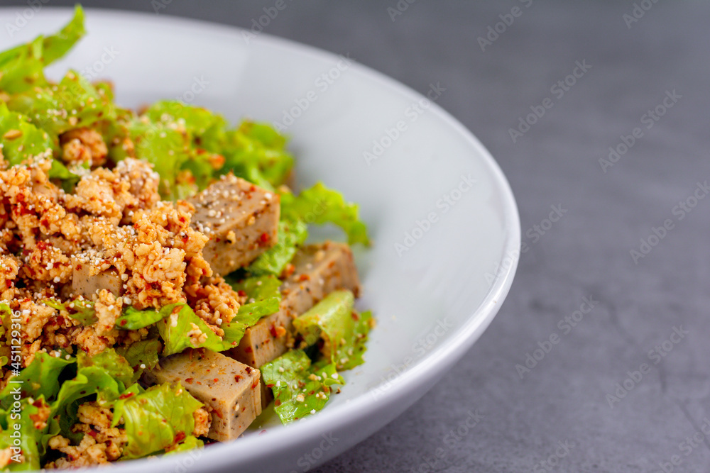 Thai spicy Vietnamese sausage with minced chicken, fish sauce, lime juice, lettuce salad on a white plate.