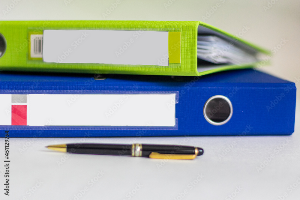 Colorful office folders on white background with pen