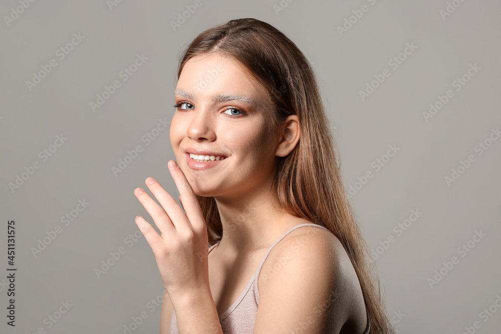 Beautiful young woman with dyed eyebrows on grey background Beautiful young woman with dyed eyebrows on grey background
