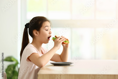 Little girl eating tasty sa...