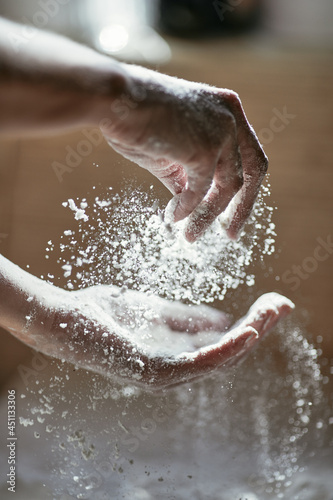 Grains of flour in the air and beautiful hand movement in the process of making cookies