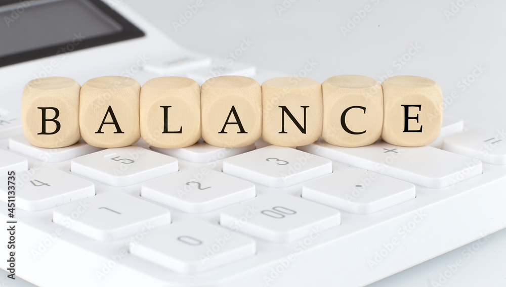 Wooden cubes with text BALANCE on the calculator, business Wooden cubes with text BALANCE on the calculator, business
