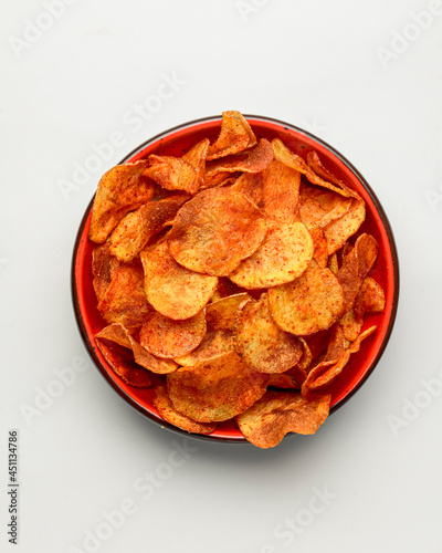 Obraz na płótnie Hot spicy potato chips bowl isolated on white, in red bowl