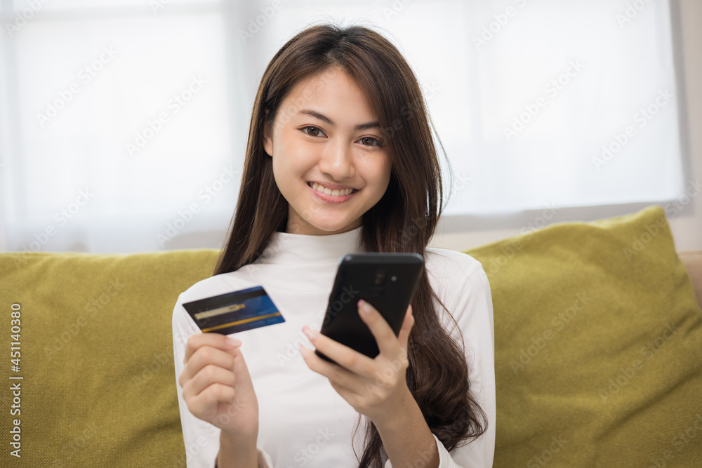 Shopping online. Young asian teenage girl input the serial number of credit card to smartphone for shopping payment. Buy item online delivery at home. Smiling female feeling happy. Shopping online. Young asian teenage girl input the serial number of credit card to smartphone for shopping payment. Buy item online delivery at home. Smiling female feeling happy.