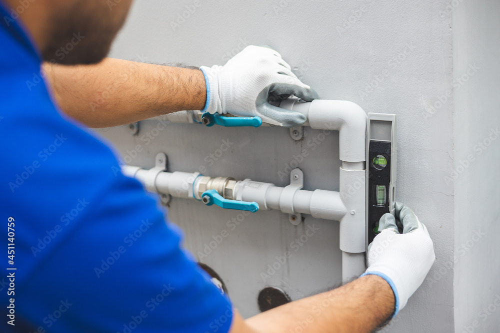 Male Plumber worker installation pipe system use spirit level for calculate. Plumbing checking service and repair. Male Plumber worker installation pipe system use spirit level for calculate. Plumbing checking service and repair.
