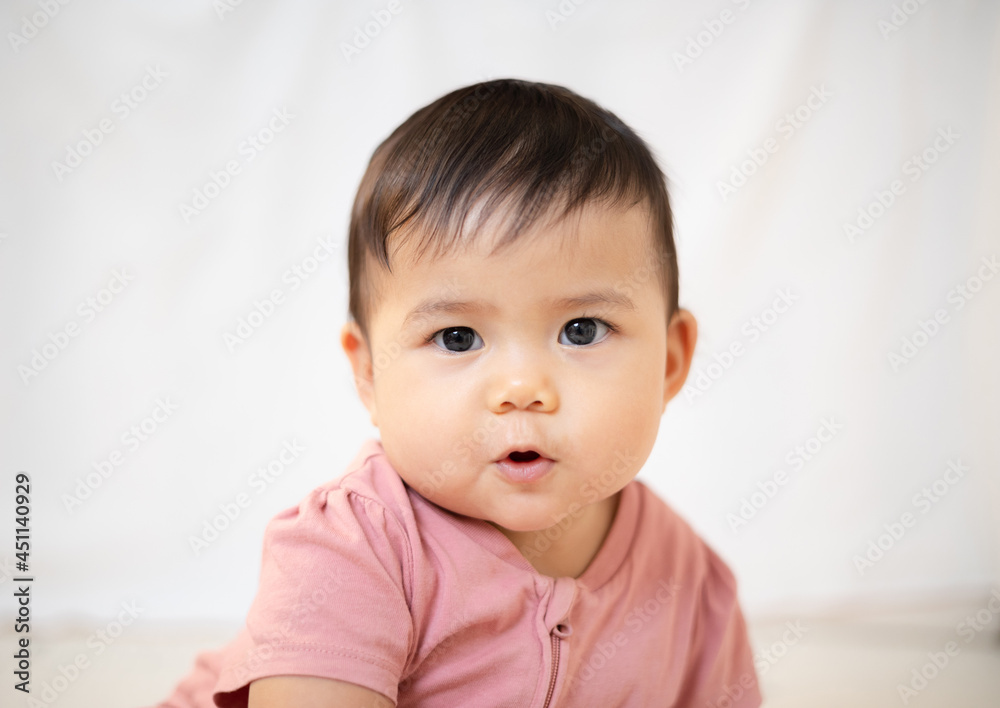 An Asian girl about 1 year old. Playing in the living room in the house. A cute baby wearing a pink dress Stay with parents in the house An Asian girl about 1 year old. Playing in the living room in the house. A cute baby wearing a pink dress Stay with parents in the house