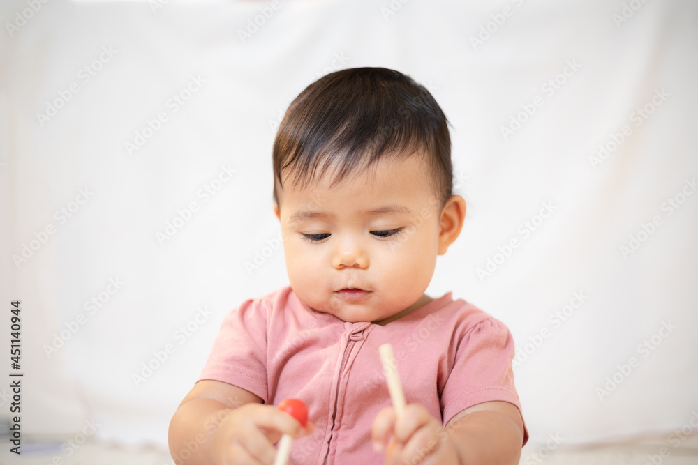 An Asian girl about 1 year old. Playing in the living room in the house. A cute baby wearing a pink dress Stay with parents in the house An Asian girl about 1 year old. Playing in the living room in the house. A cute baby wearing a pink dress Stay with parents in the house