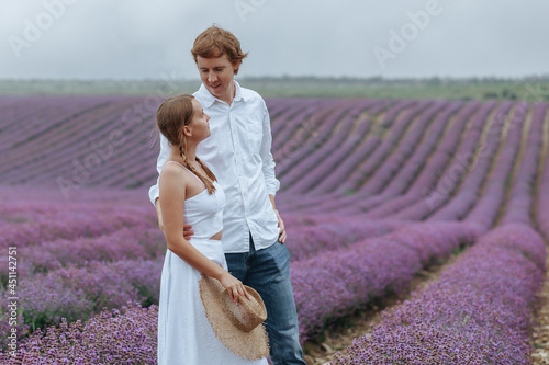 Fototapeta Naklejka Na Ścianę i Meble -  A couple in love in a lavender field in white clothes