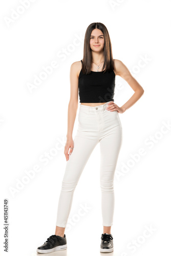 a teenage girl in white jeans and a black shirt