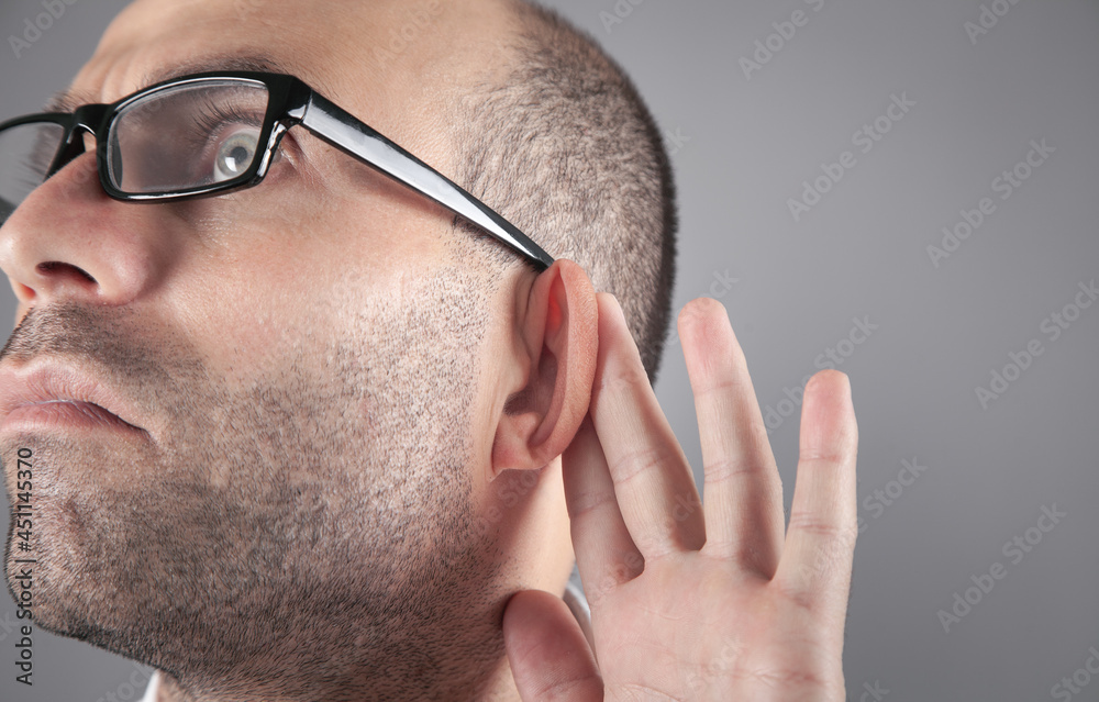 Caucasian man hold hand near ear. Trying to hear a gossip Caucasian man hold hand near ear. Trying to hear a gossip