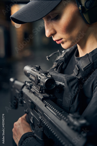 Female shooter in earmuffs preparing to fire a weapon