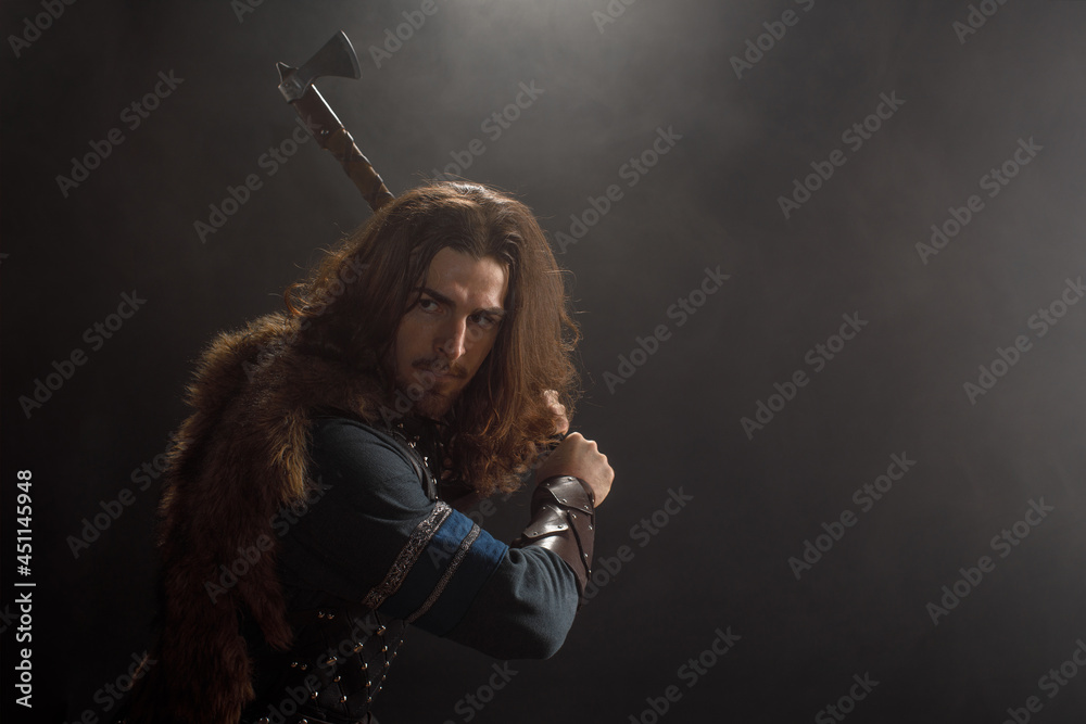 Close-up medieval knight with ax in armor on black background. Historical concept