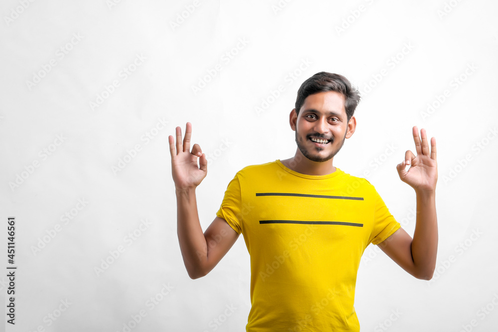 Young indian man showing direction with hand over white background. Young indian man showing direction with hand over white background.