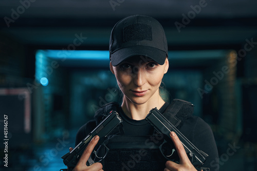 Serene female shooter posing for the camera with two pistols photo