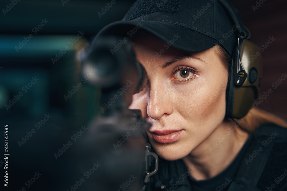 Lovely young female shooter firing a weapon Lovely young female shooter firing a weapon