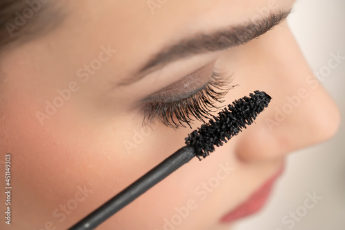 closeup of a woman applying mascara on her eyelashes