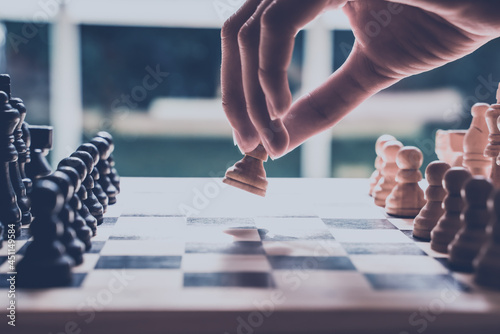 Photography Hand moving a chess piece across the board