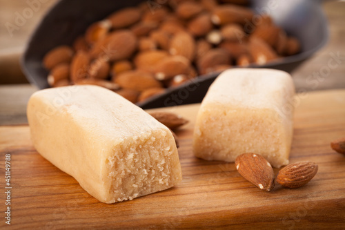 Marzipan bars and almonds on chopping board photo